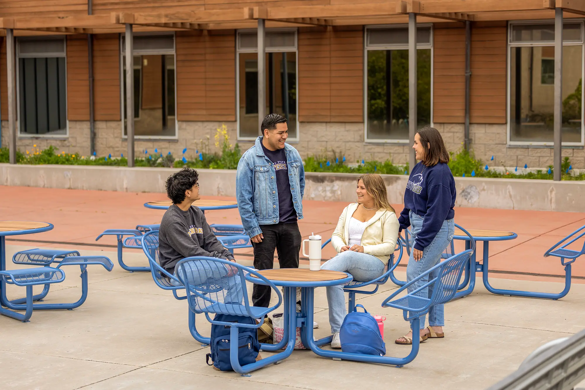 A group of students sitting and standing around a table outside Chapman
