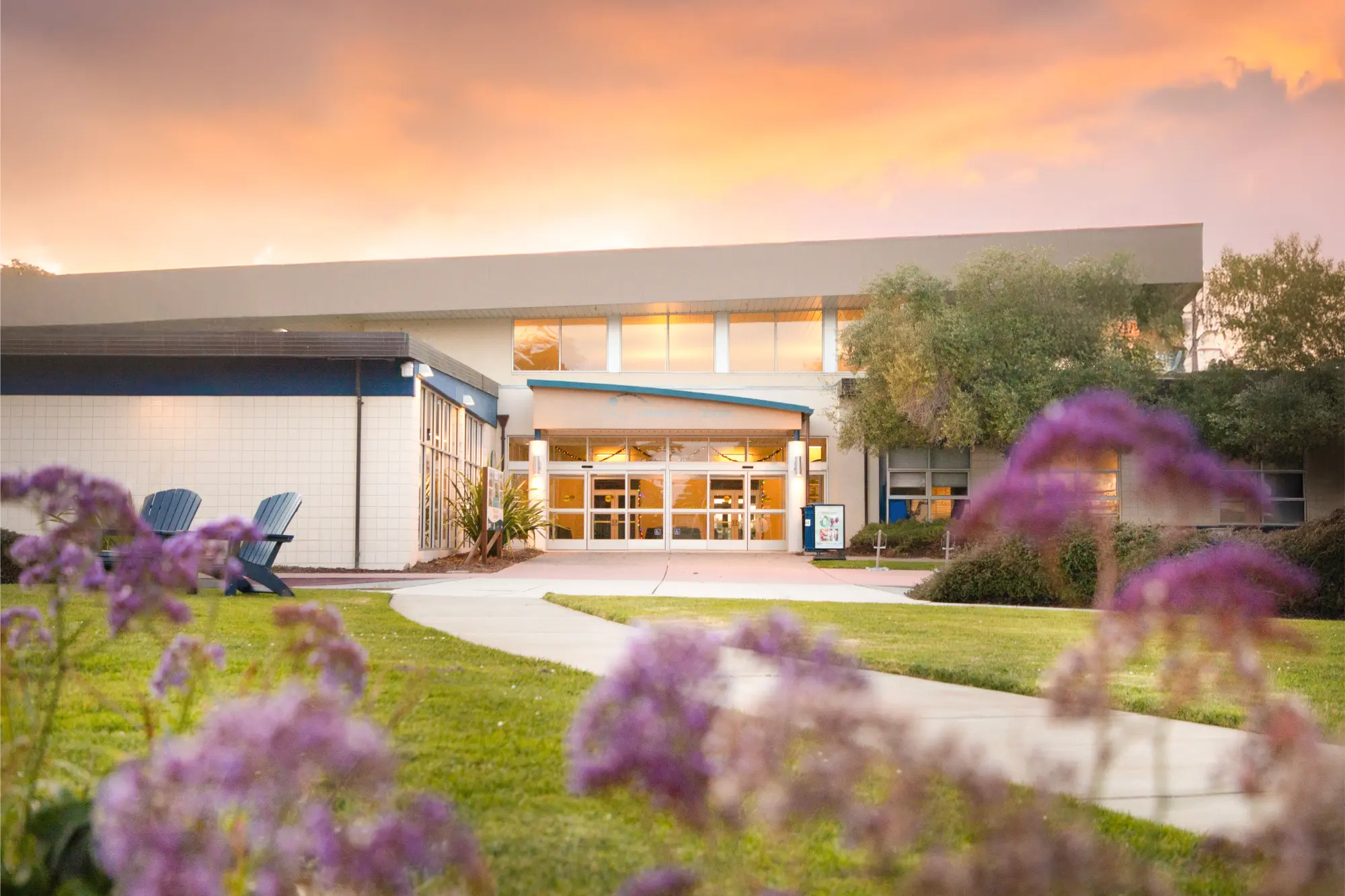 A landscape of a building with a sunset in the background