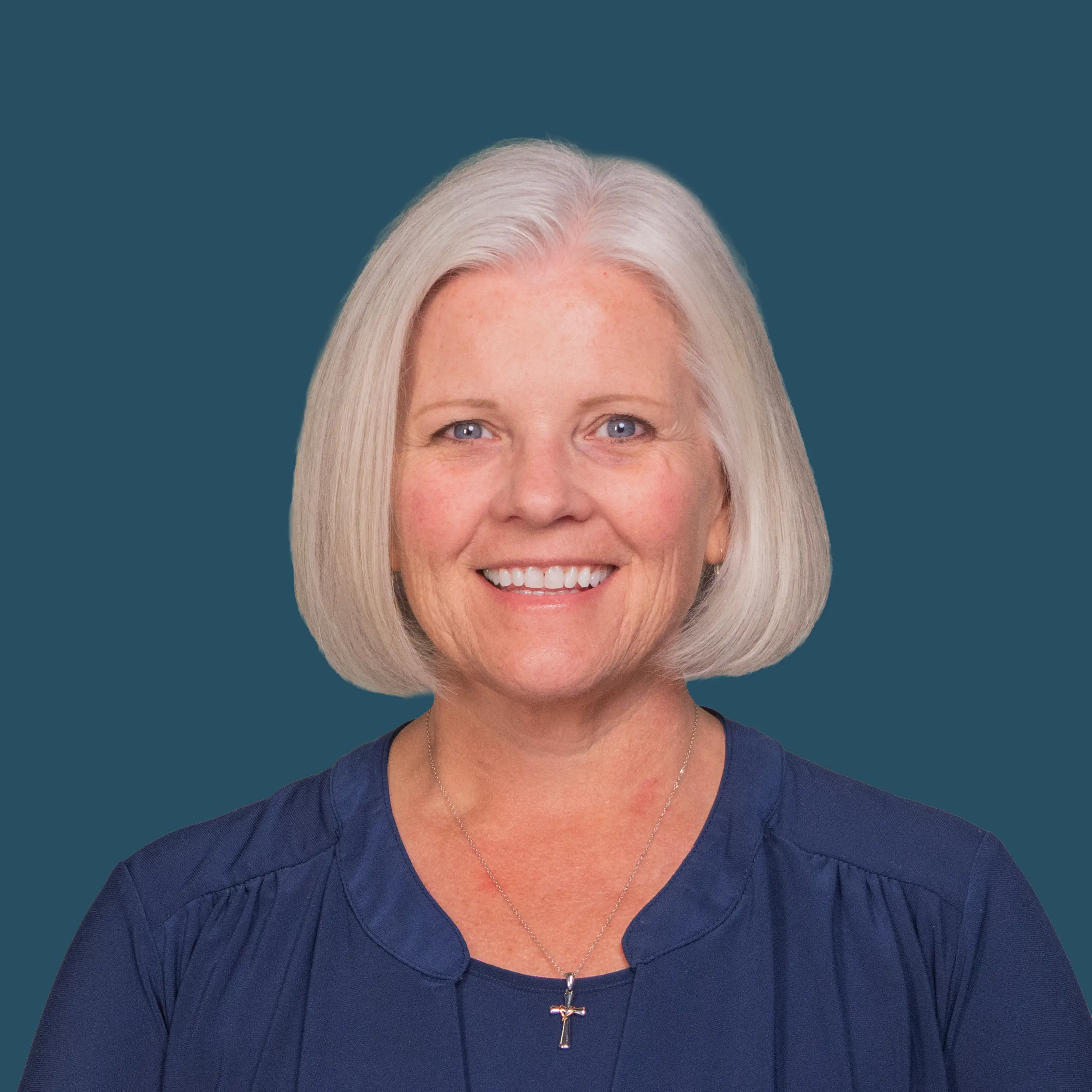 Portrait of Amy Thomas smiling against a blue background.