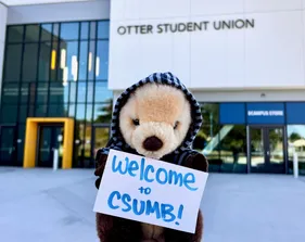 Mini Monte sitting in front of the OSU holding up a 