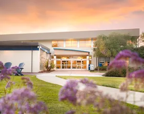A landscape of a building with a sunset in the background