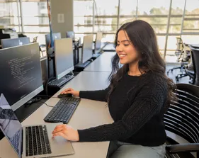 A student sitting down inside a computer lab in the business and information technology building