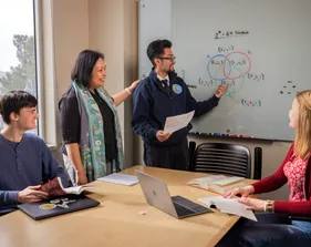Three statistics students in a meeting with Dr. Deka