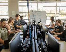 A group of students working on their desktops in the network and security lab in the business and information technology building