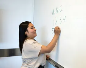 Student writing on a whiteboard.