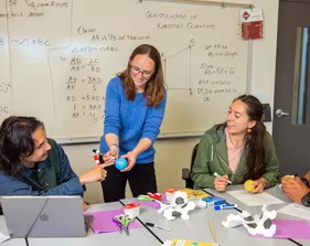 Professor interacting with a student while teaching him a math concept.