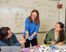 Professor interacting with a student while teaching him a math concept.