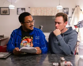 Two film crew members talking besides each other at a table
