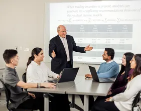 An accounting professor presents to a class