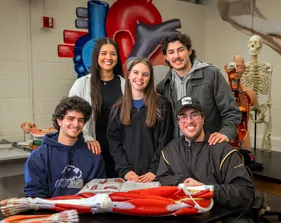 A group of kinesiology students posing and smiling at the camera