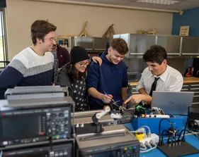 A group of four mechatronics students grouped together collaborating