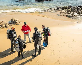 Students prepare for a coastal diving activity with an instructor, engaging in hands-on learning in the marine environment.