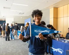 New student holding 911���ϱ����� pennant and cowbell.