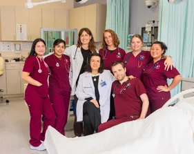 Group picture of all the nurses in the hospital smiling with each other.