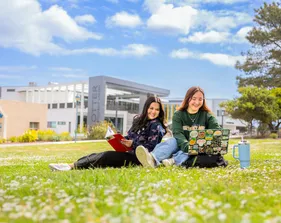 Two female students studying at the campus quad