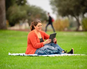 Student reading on blanket