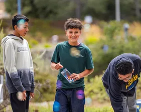 Three students outdoors at camp