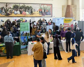 Lots of booths with people walking by at a career fair.