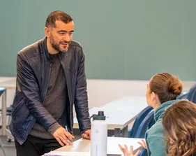 Teacher talking to students during a classroom discussion.
