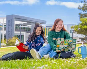 Two female students studying at the campus quad