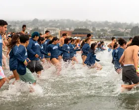 Students splash into the ocean at the Otter Plunge