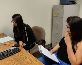 two students at a table looking at a computer screen in a research lab