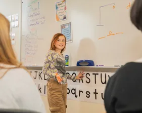 Child playing hangman on a whiteboard