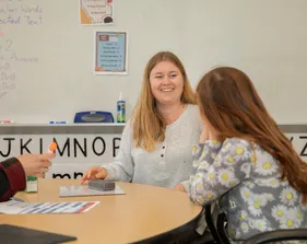 Teacher helping a kid read in the reading center