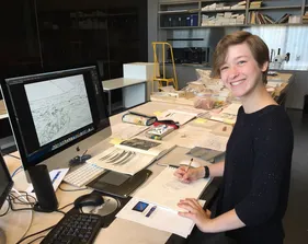 Girl sitting in front of computer and smiling