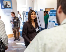 A student presenter presents their presentation to an audience member