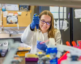 A girl is sitting in a lab and working on something