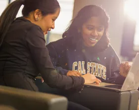 Two students looking at laptop together