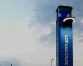 An emergency blue light phone on campus at twilight.
