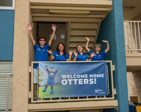 Students posing for picture on balcony outside student accommodation