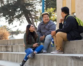 3 students sitting next to each other talking