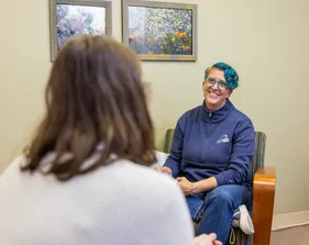 Two girls are sitting on the chairs and talking to each other