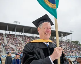 Dean holding college pole