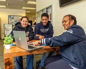 students sitting around a computer at a table