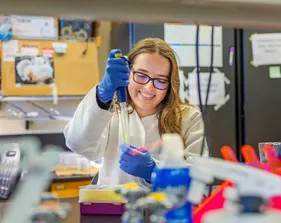 A girl is sitting in a lab and working on a project