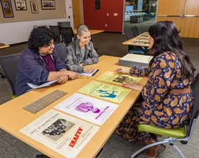 Students talking with the professor at a desk