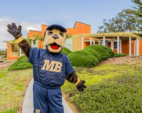The campus mascot welcomes visitors outdoors, highlighting school spirit and a friendly, inviting environment.
