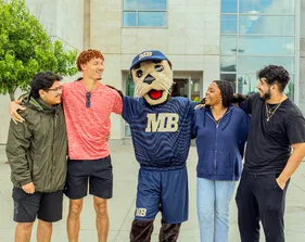 Monte hanging out with a group of students in front of the library