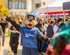 Mascot engages with students during a campus event, promoting school spirit and community connection.