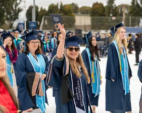 CSUMB graduates walking and waving to the crowd
