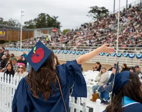 New CSUMB teacher graduate waving to the crowd