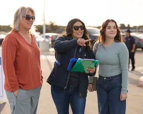 A staff member guides visitors during a campus tour, pointing out key locations and fostering a welcoming experience.