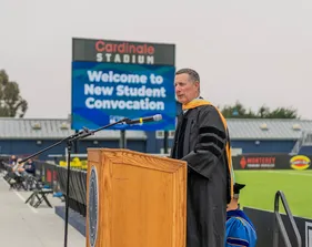 Cabinet member speaking at a podium during convocation