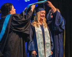 student in cap and gown at ceremony