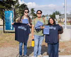 Students holding CSUMB t shirts