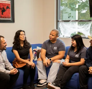 Group of people sitting on the sofa and having conversation